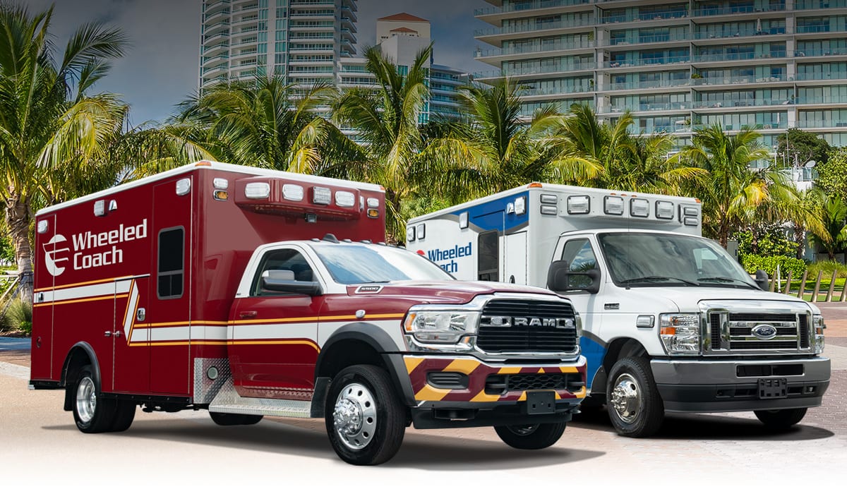 Two Wheeled Coach ambulances side by side in front of palm trees and buildings