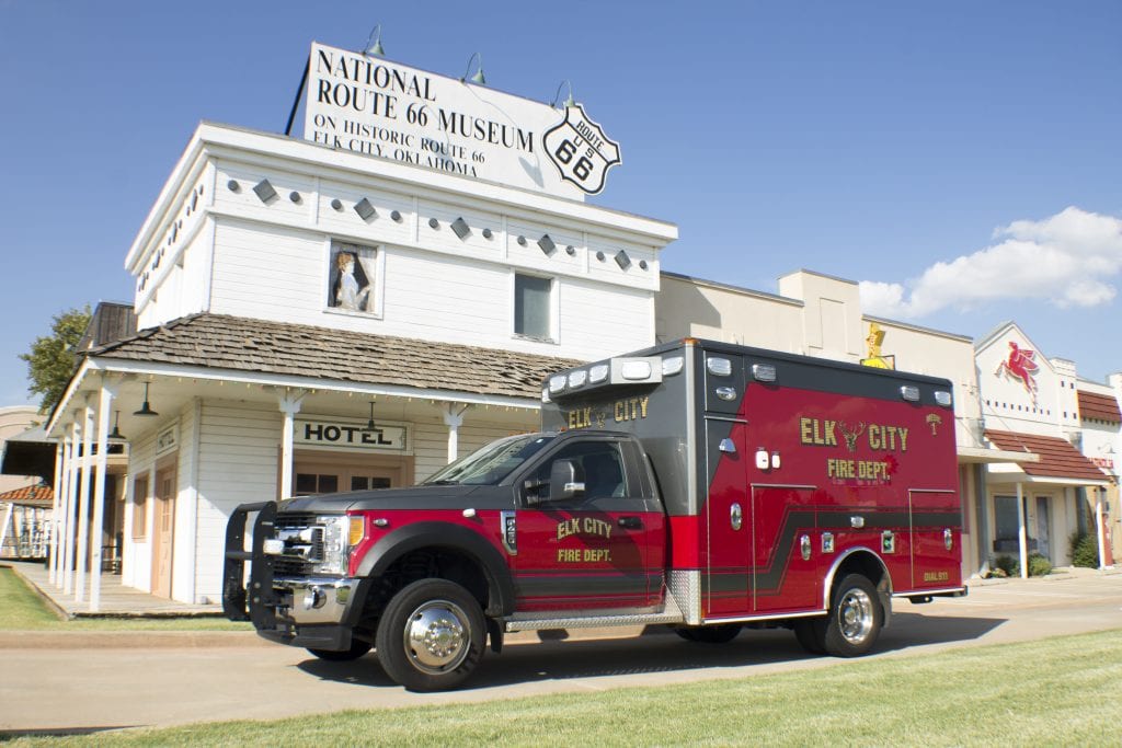 Side view of ambulance for Elk City Fire Department in front of buildings