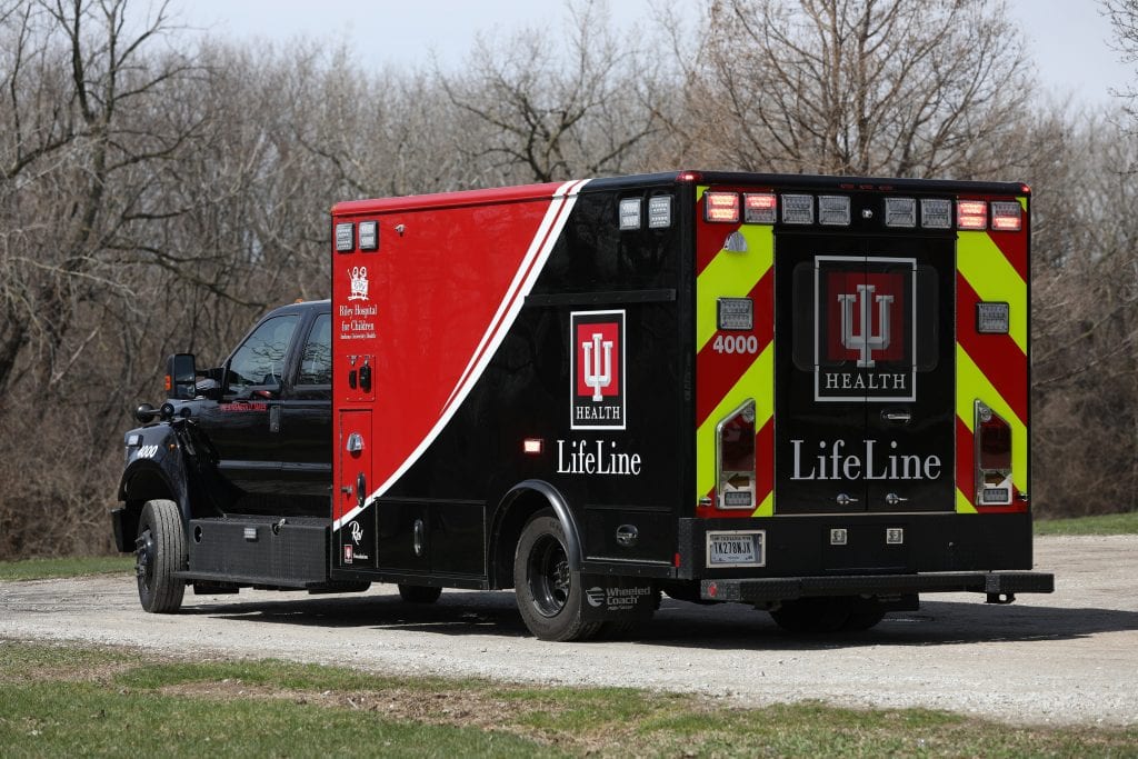 LifeLine Health ambulance on road in front of trees in winter
