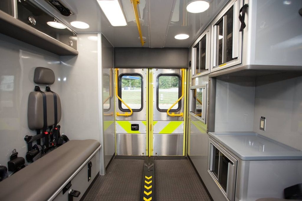 Inside of ambulance showing back doors, cabinets and seat