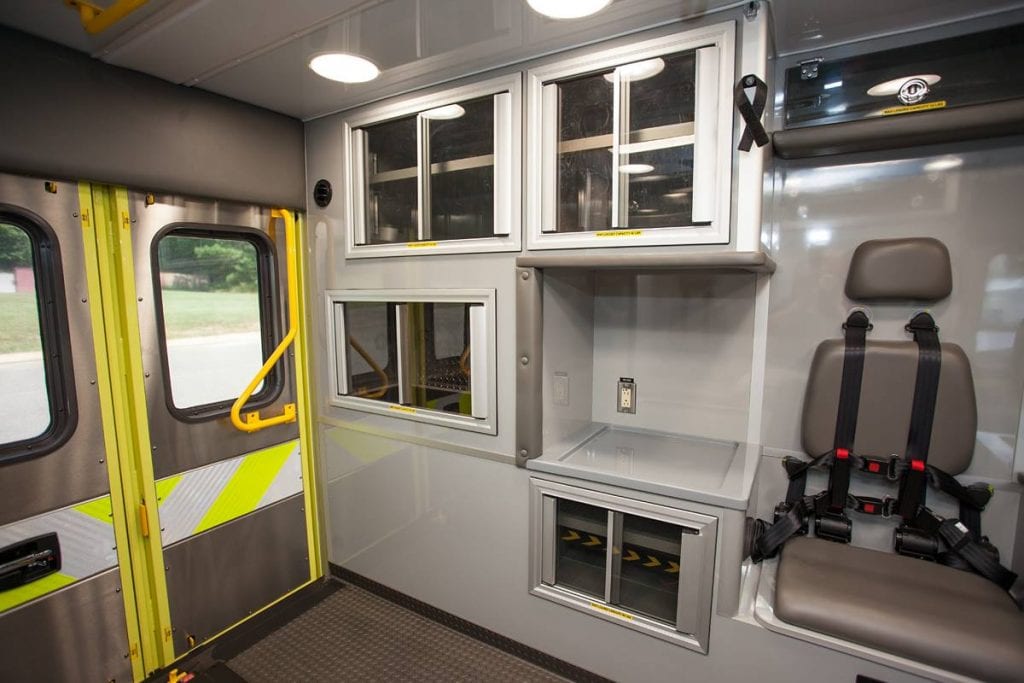 Inside of ambulance showing back doors, cabinets and seat