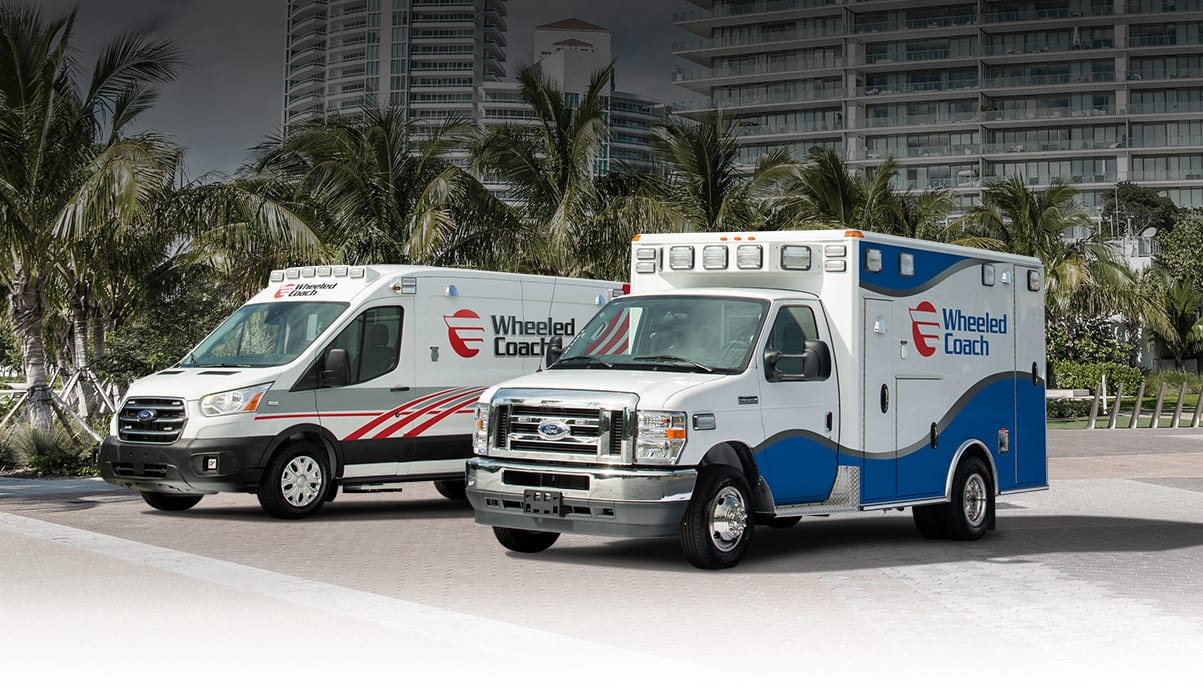 Two Wheeled Coach ambulances in front of palm trees and buildings